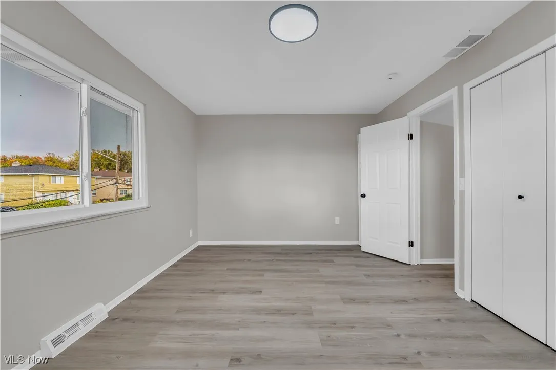 Unfurnished bedroom featuring light wood-type flooring and a closet