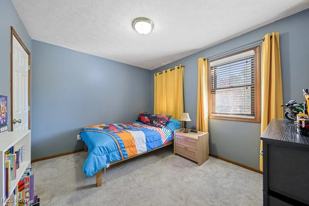 Bedroom with carpet and a textured ceiling