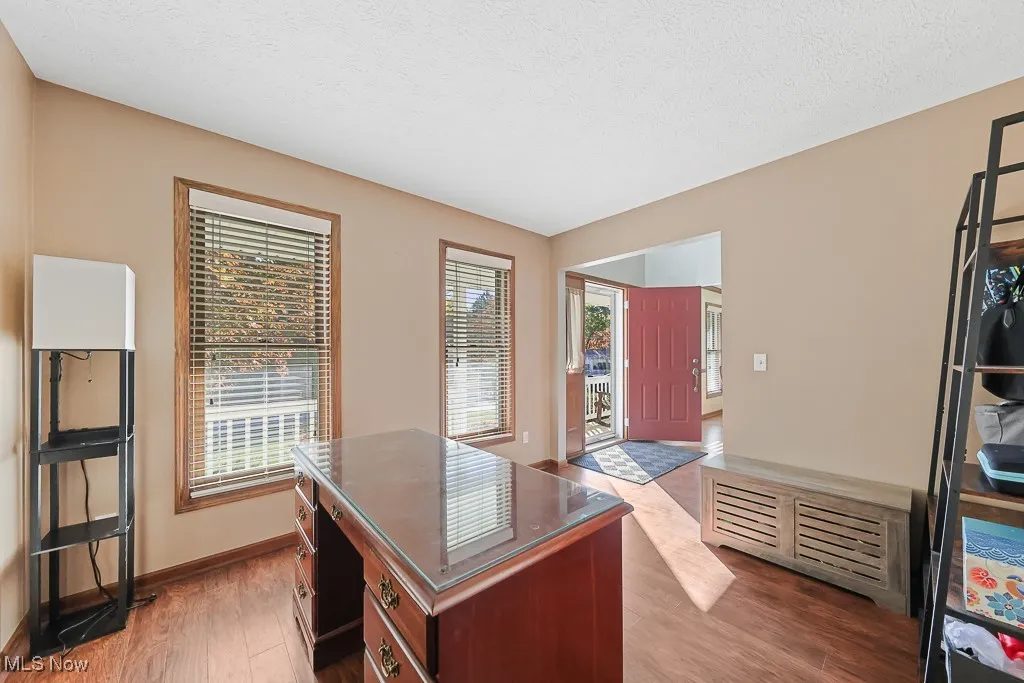 Home office with light wood finished floors and a textured ceiling