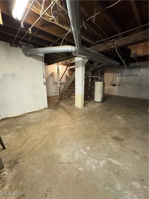 Unfinished below grade area with water heater and stairway