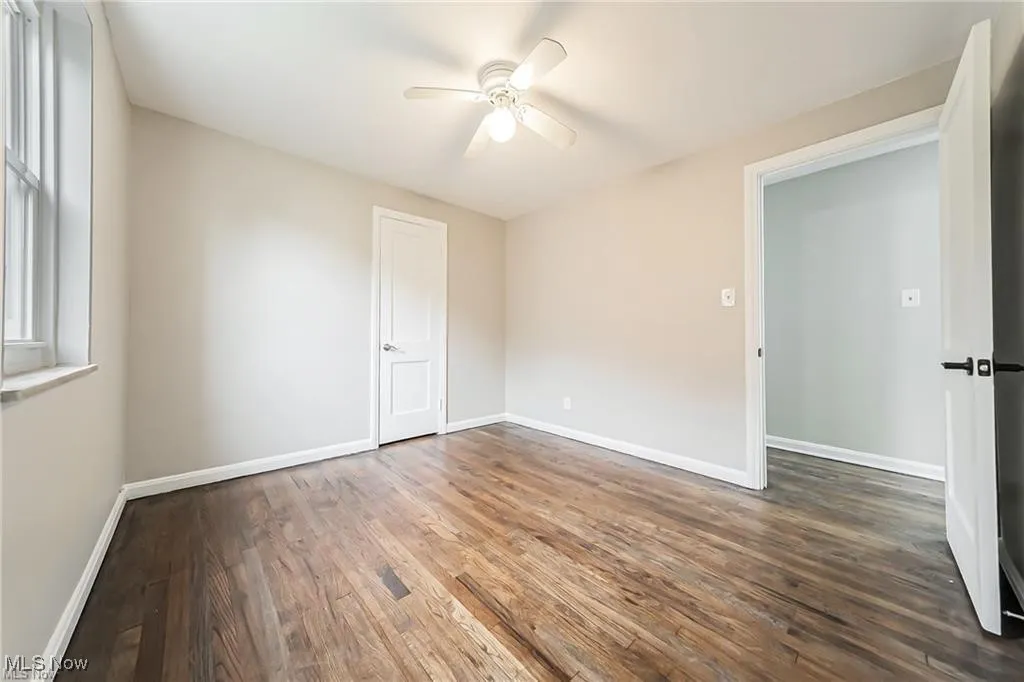 Empty room featuring dark wood finished floors and ceiling fan