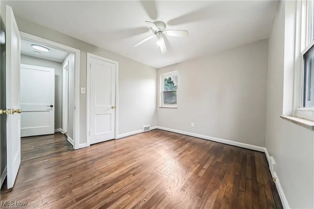 Unfurnished bedroom with dark wood finished floors and ceiling fan