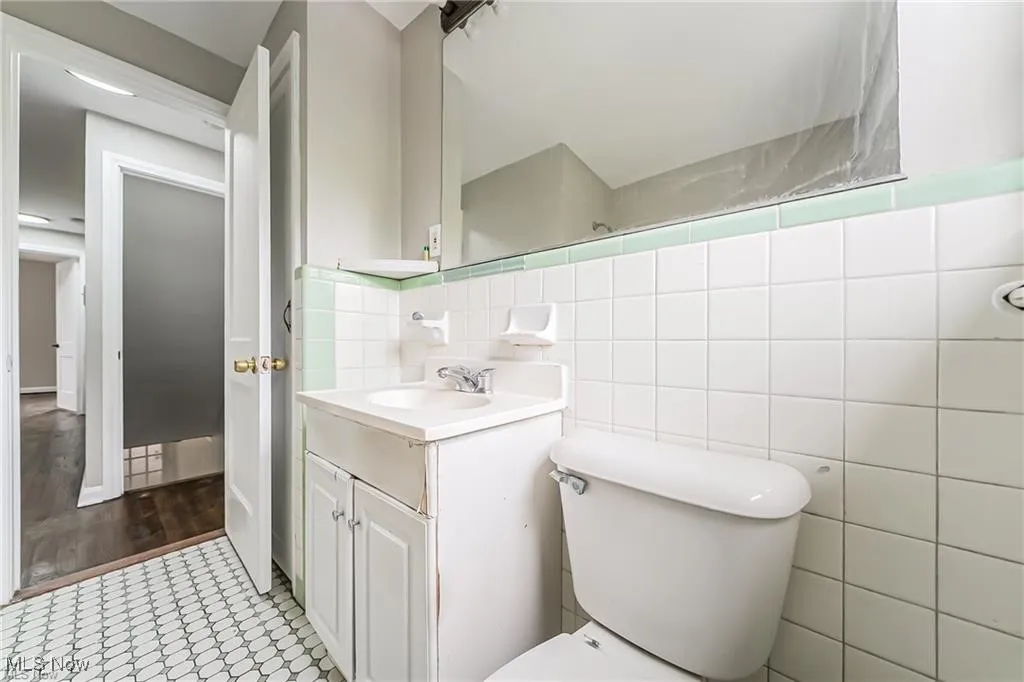 Bathroom with vanity, tile walls, and light tile patterned floors