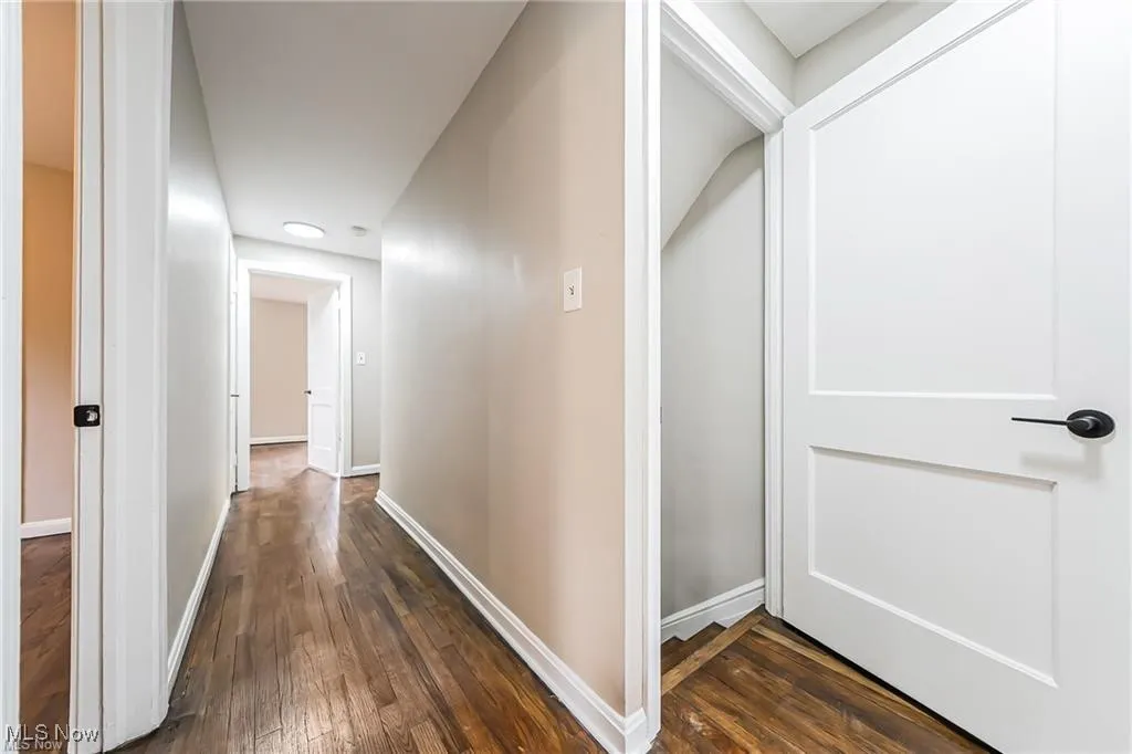 Corridor featuring dark wood finished floors