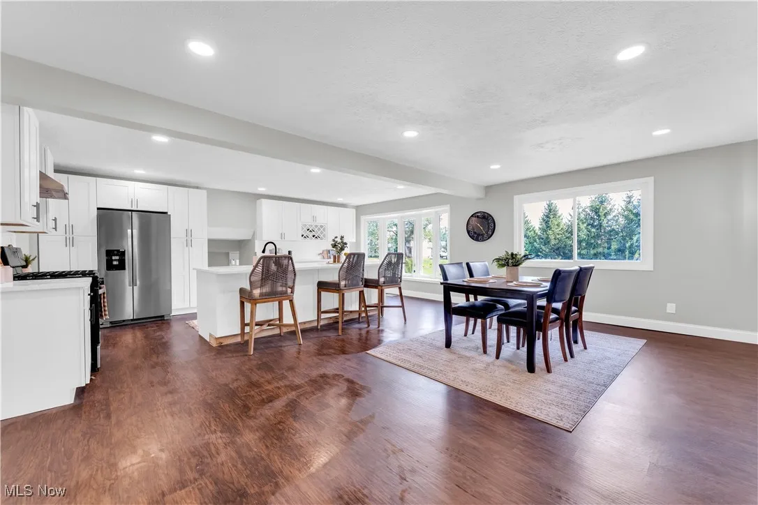 Dining area with dark wood-style flooring, recessed lighting, and beam ceiling