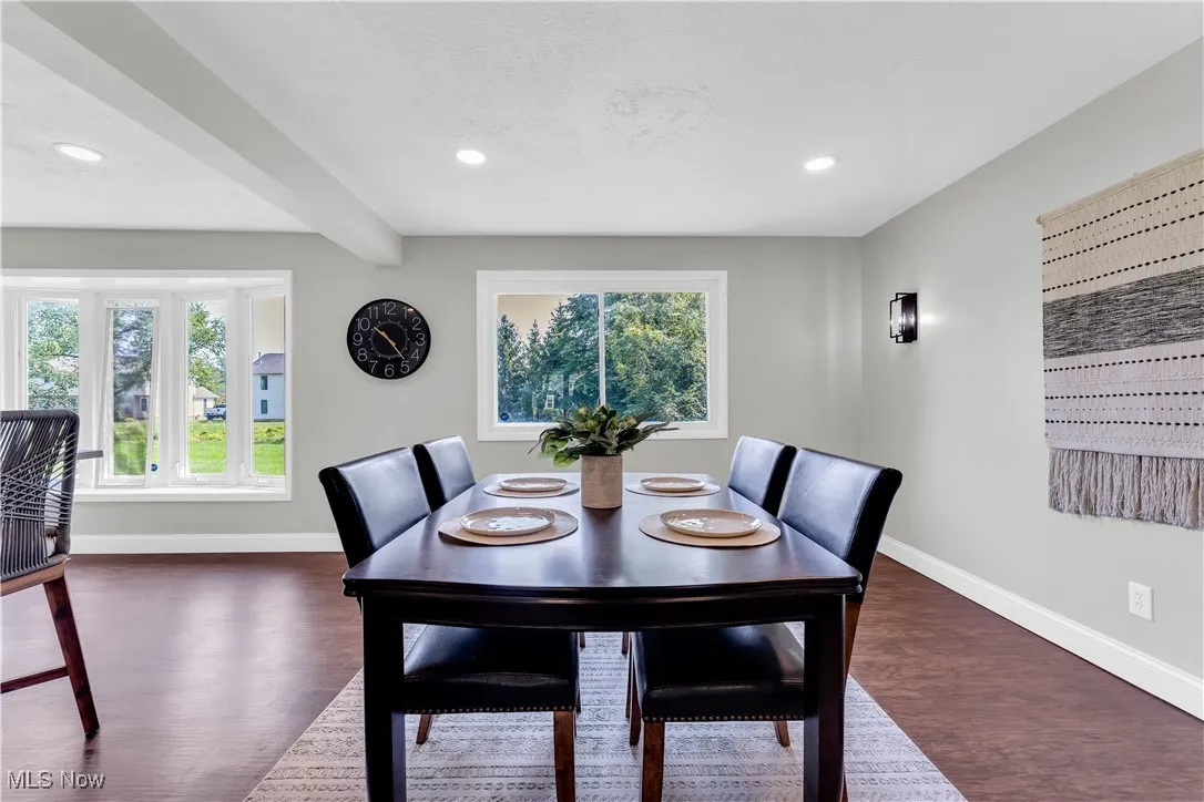 Dining space featuring beamed ceiling, dark wood-style flooring, and recessed lighting