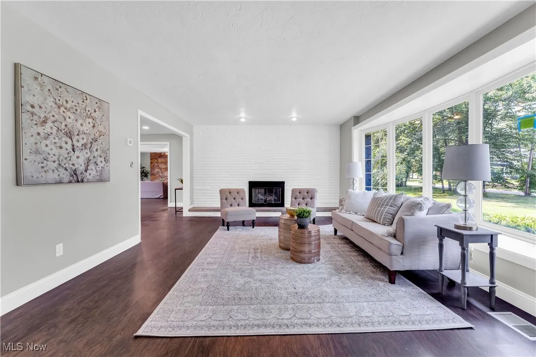 Living area featuring dark wood-type flooring, a fireplace, and a textured ceiling