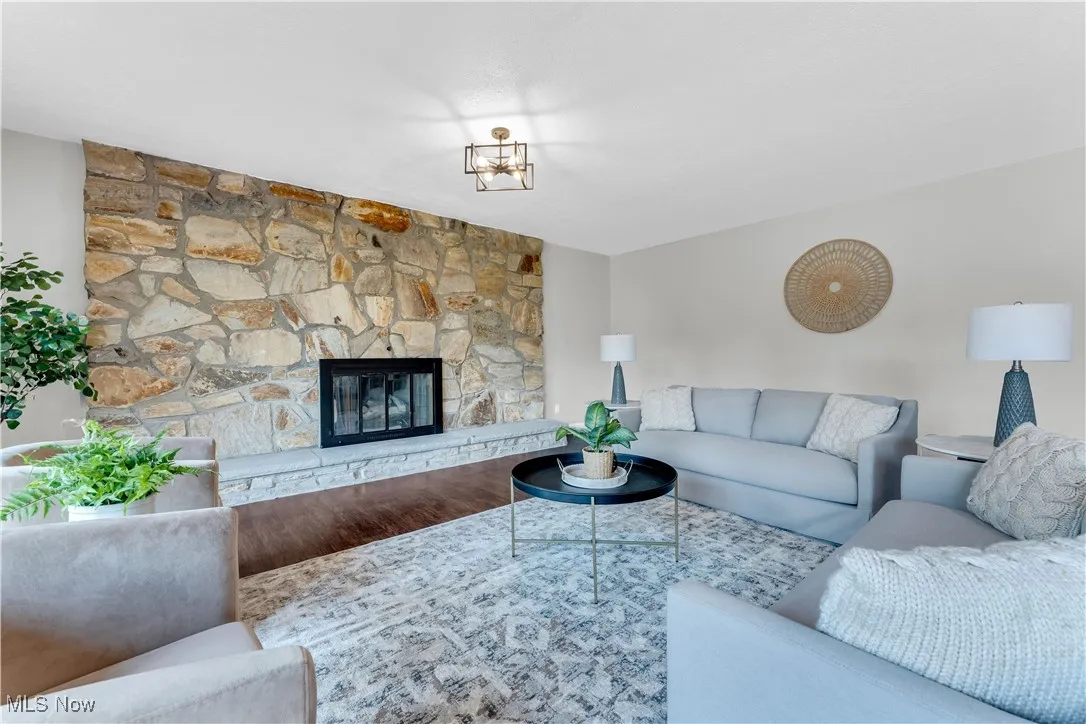 Living area featuring wood finished floors and a stone fireplace