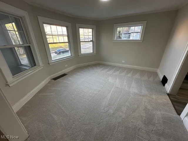 Empty room with light carpet and crown molding