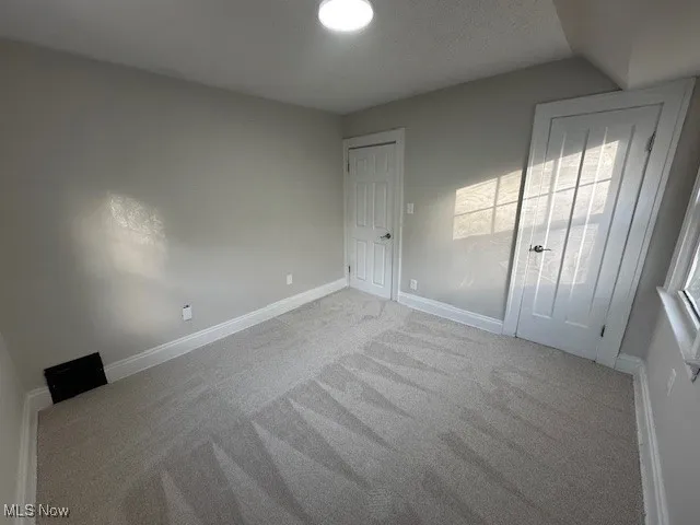 Unfurnished bedroom featuring a textured ceiling and carpet flooring