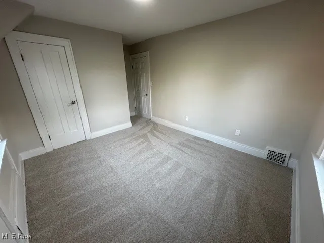 Unfurnished bedroom with carpet flooring and a closet