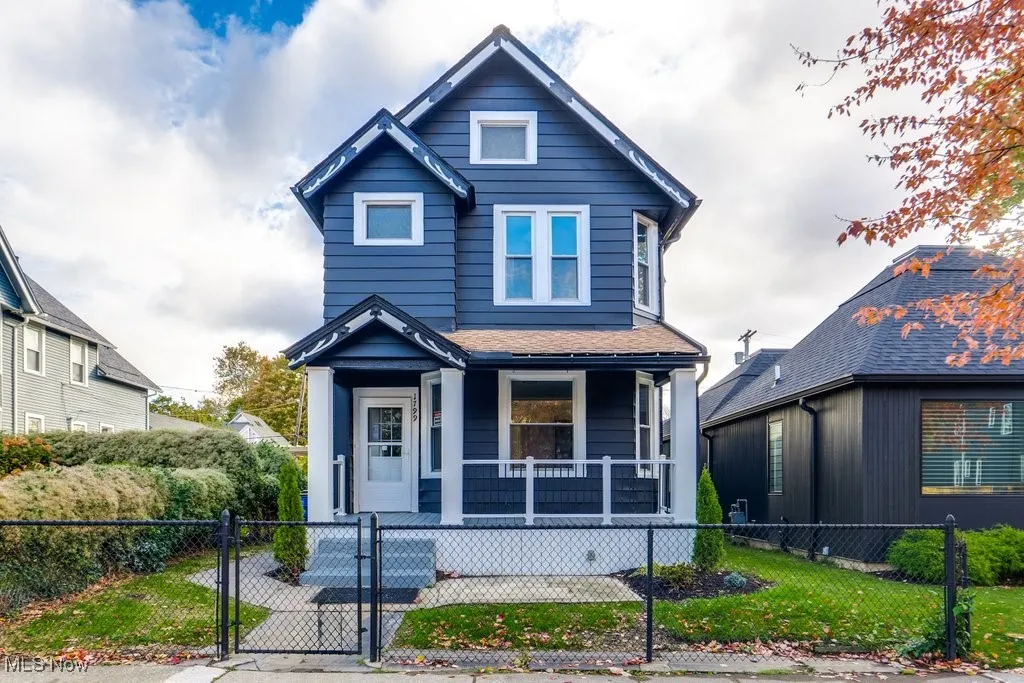View of front facade featuring a gate, covered porch, and a fenced front yard