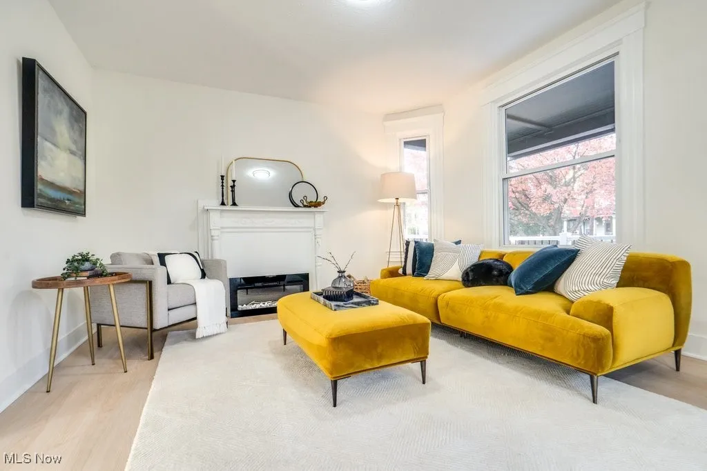 Living area featuring light wood finished floors and a glass covered fireplace