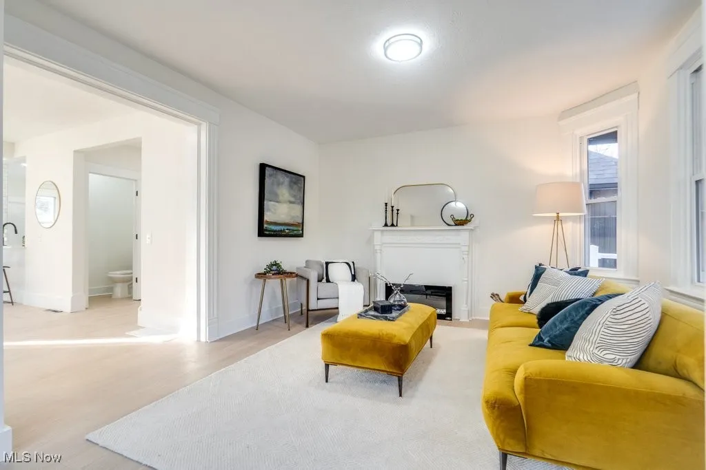 Living room with wood finished floors and a glass covered fireplace