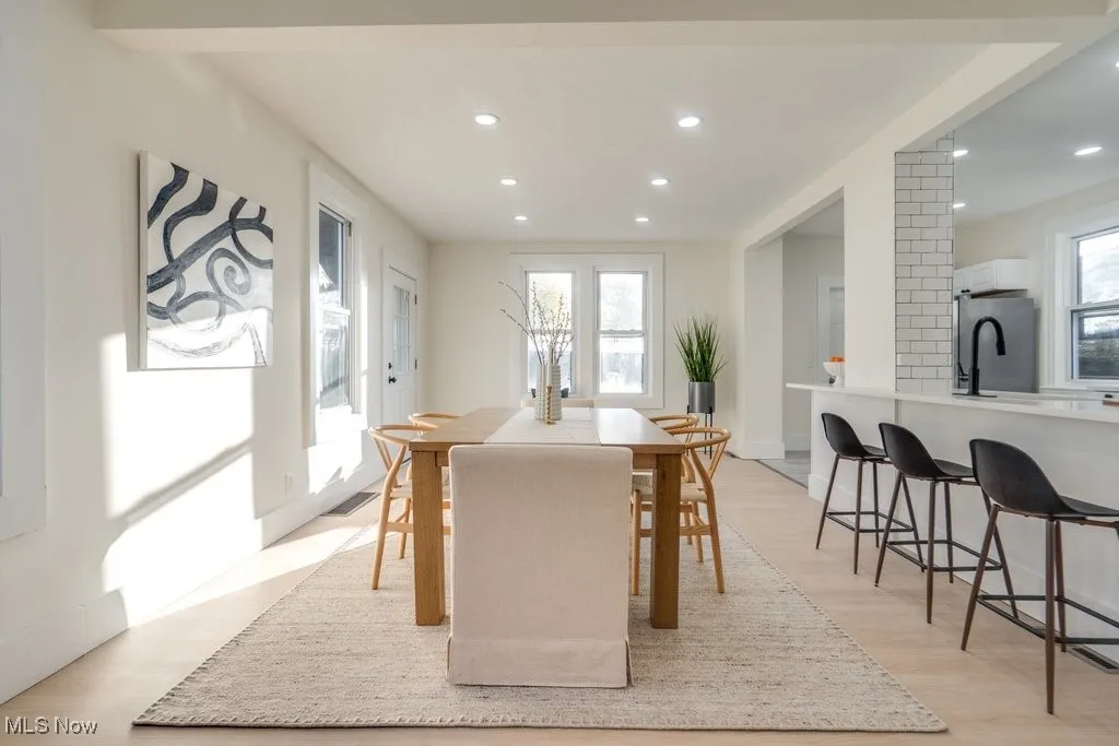 Dining space with light wood finished floors and recessed lighting