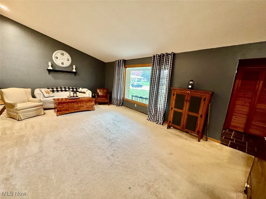 Carpeted living area with vaulted ceiling