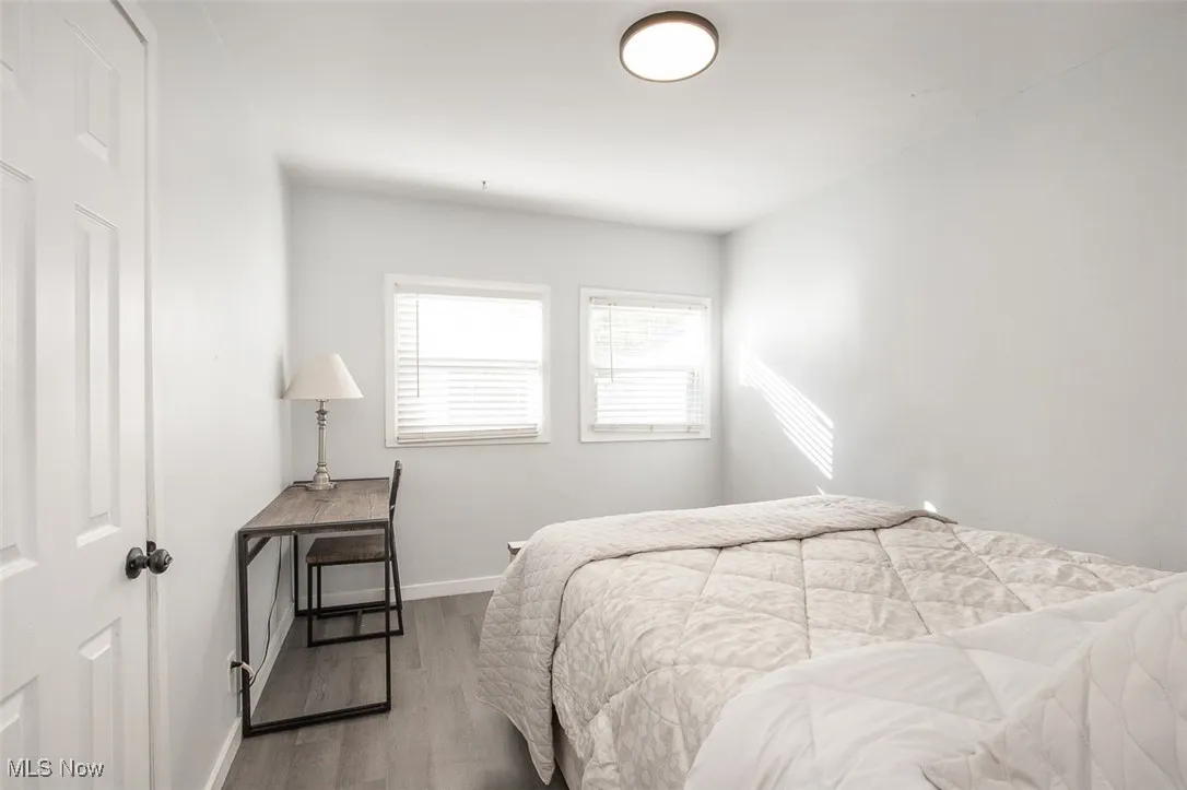 Bedroom with wood finished floors and baseboards