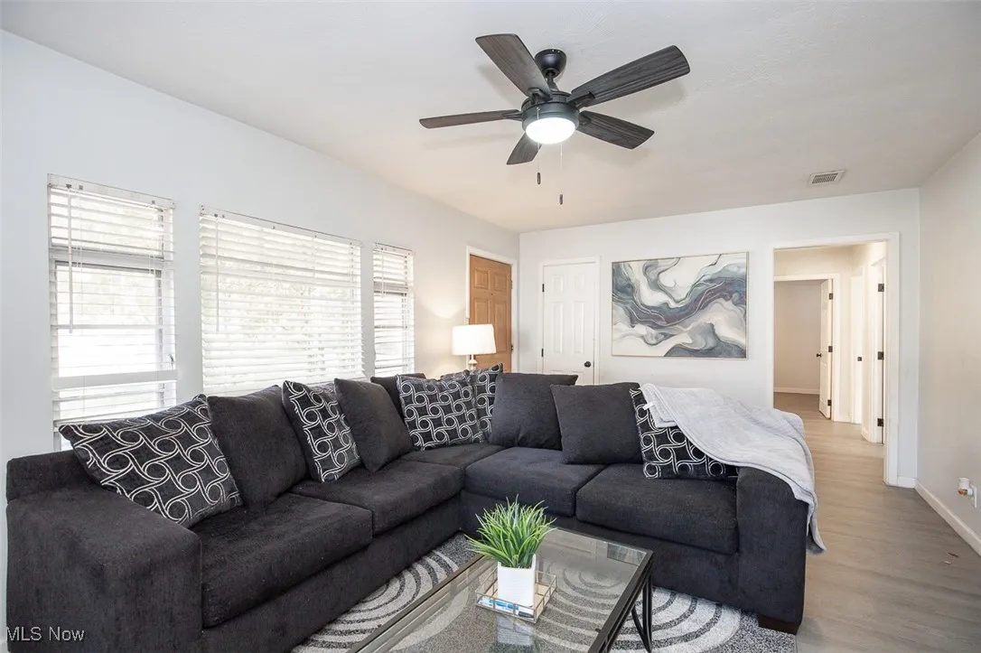 Living area with wood finished floors and a ceiling fan