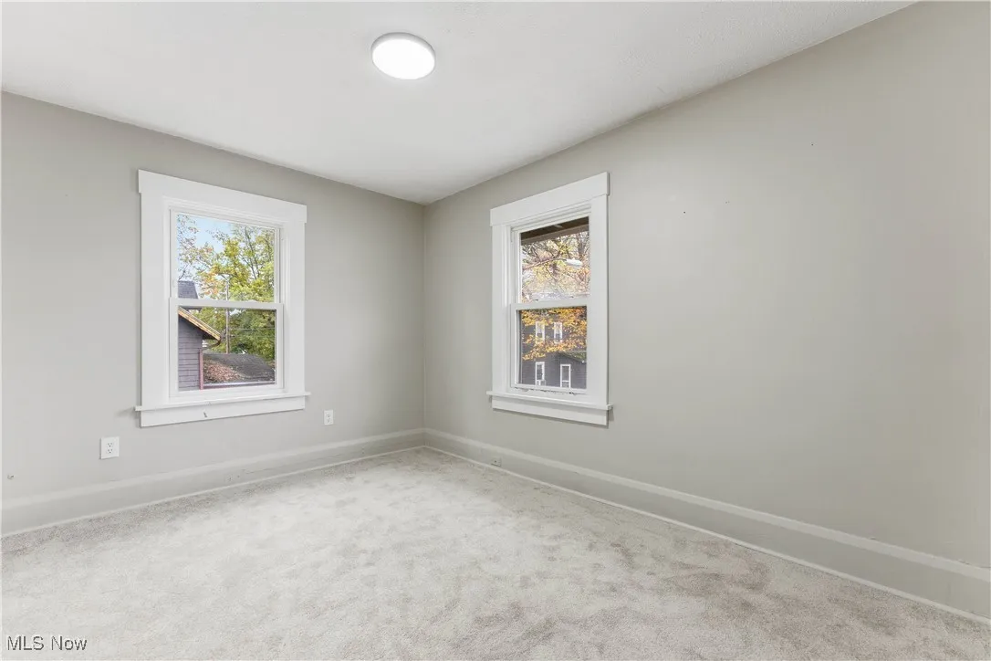 Carpeted spare room featuring baseboards