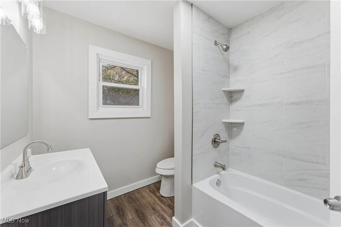 Full bathroom with vanity, bathtub / shower combination, and dark wood-style flooring