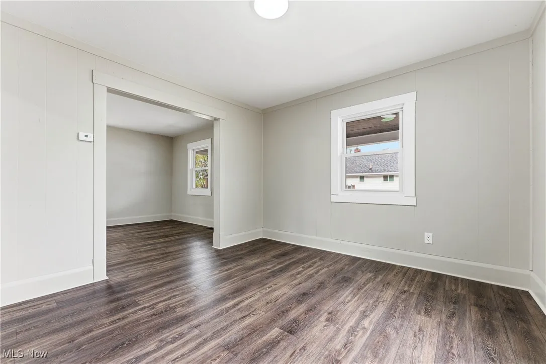 Unfurnished room featuring dark wood-style flooring