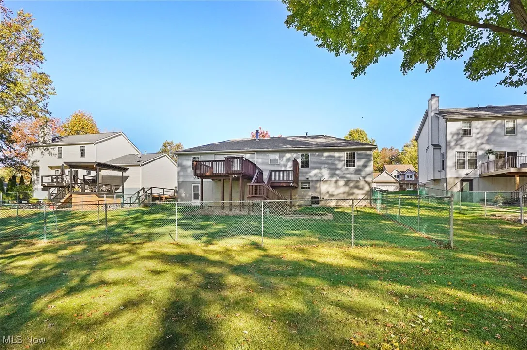 Rear view of house with stairs, a deck, and a fenced backyard
