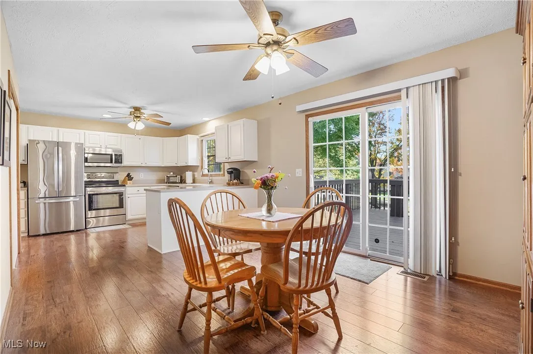Dining area featuring light wood-style flooring, a ceiling fan, and a textured ceiling