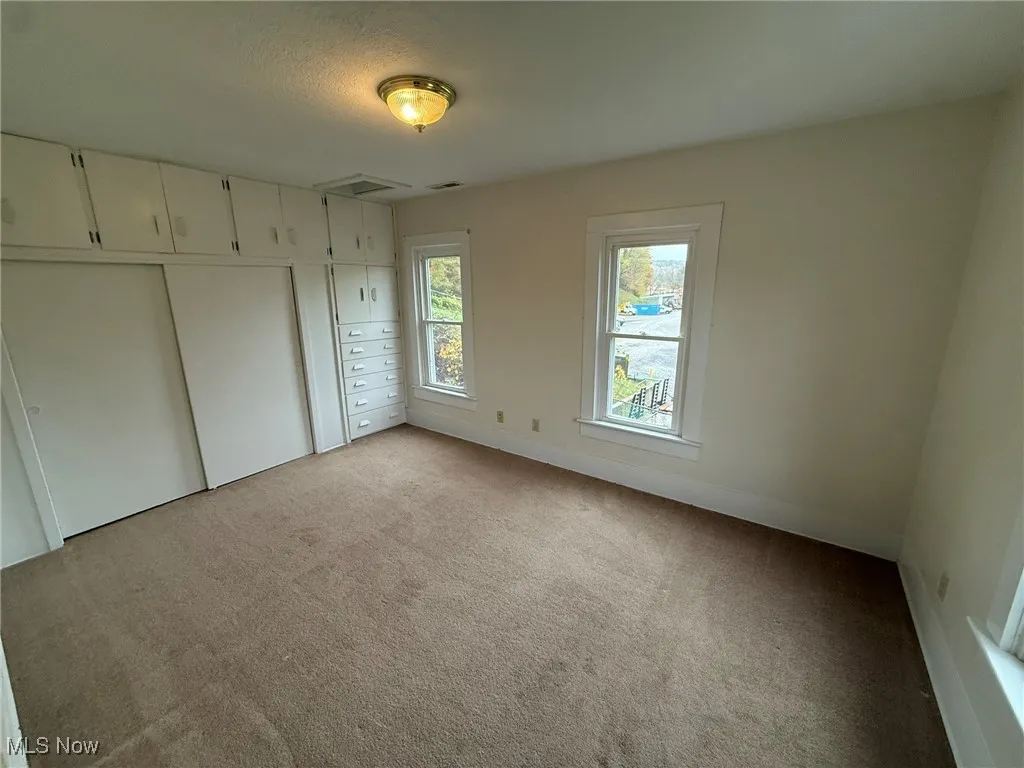 Unfurnished bedroom featuring light colored carpet and a closet