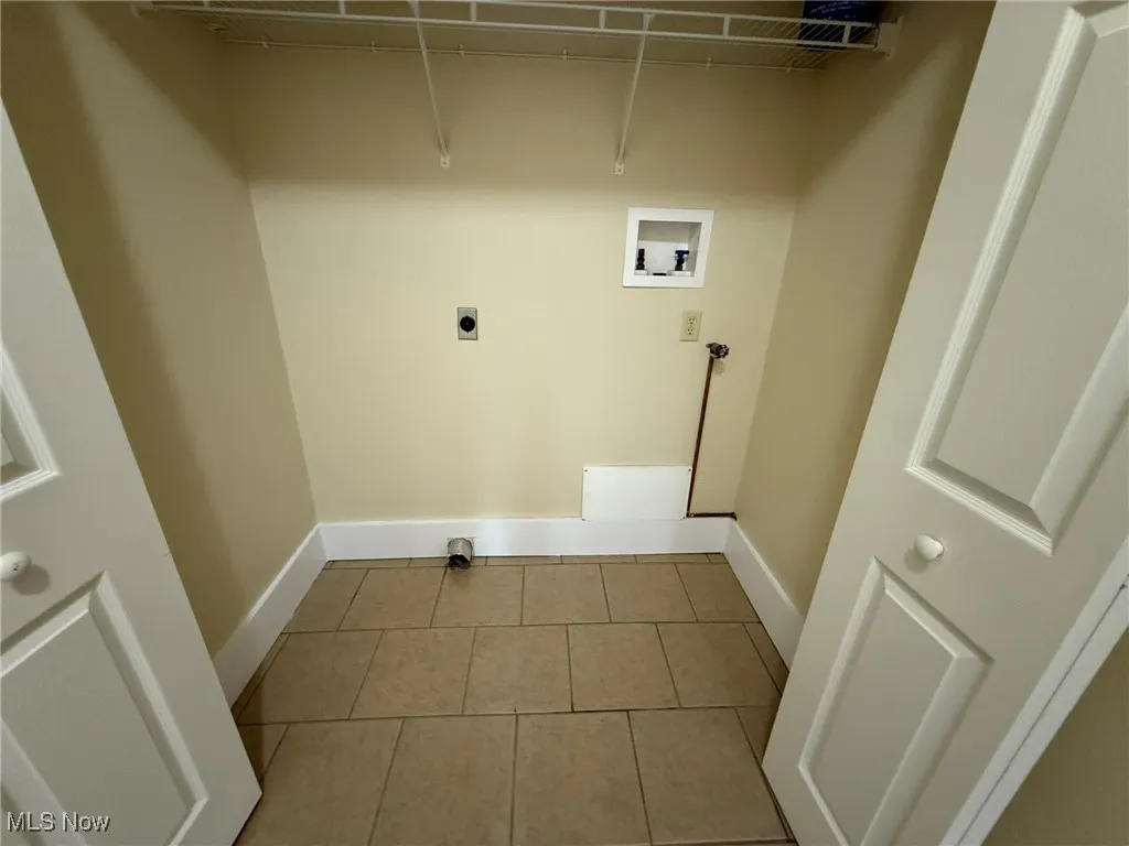 Laundry room with light tile patterned floors, hookup for a washing machine, and electric dryer hookup