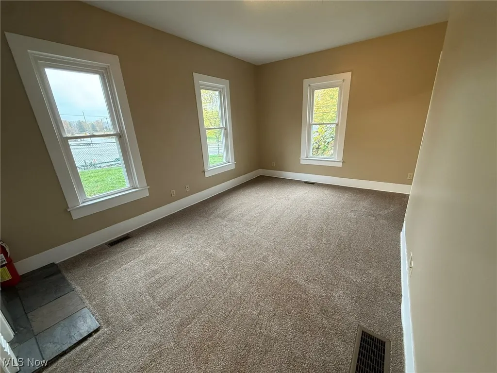 Unfurnished room with baseboards and carpet