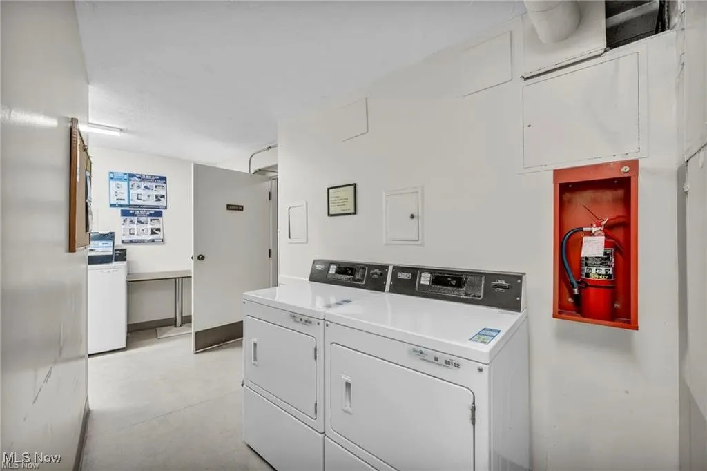 Communal laundry room featuring washer and clothes dryer