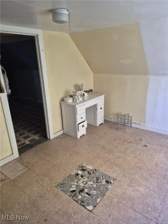 Bonus room featuring lofted ceiling and baseboards