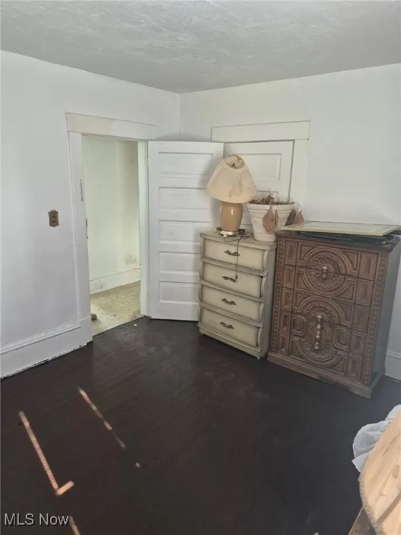 Sitting room featuring dark wood-type flooring and a textured ceiling