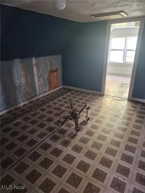 Additional living space featuring tile patterned floors and baseboards