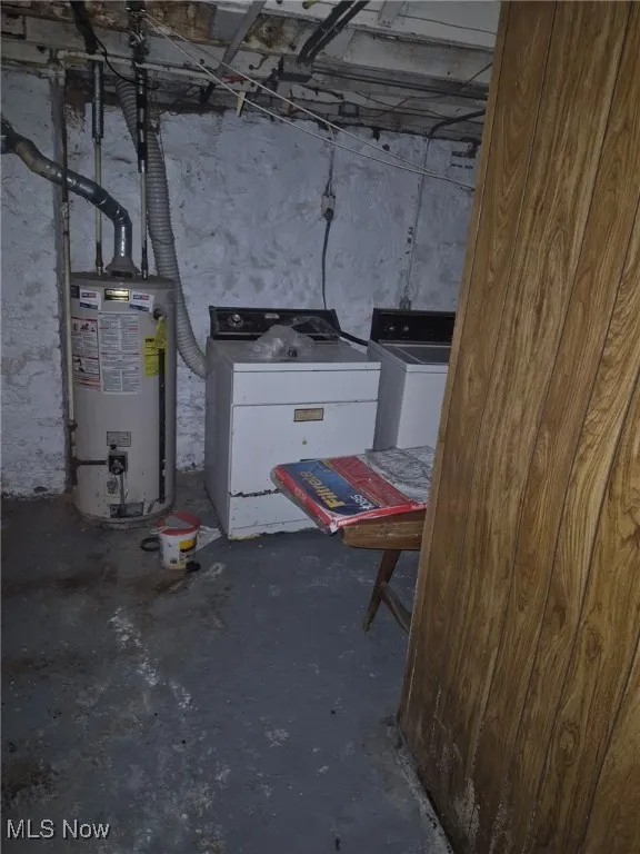 Unfinished below grade area featuring gas water heater and washing machine and dryer