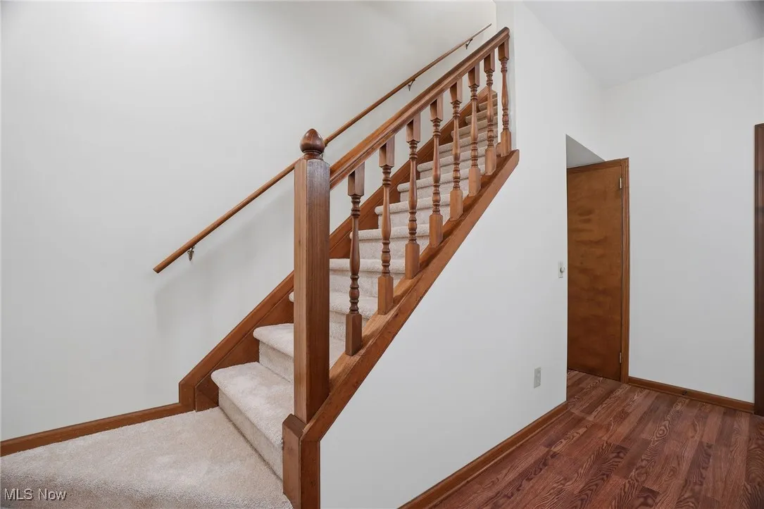 Staircase with baseboards and wood finished floors