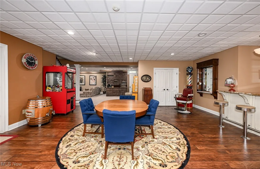 Dining room with dark wood-type flooring and recessed lighting