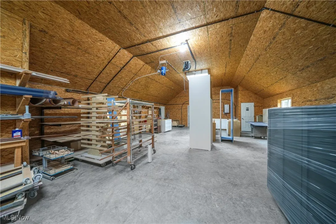 Bonus room featuring lofted ceiling, concrete flooring, and washer / clothes dryer