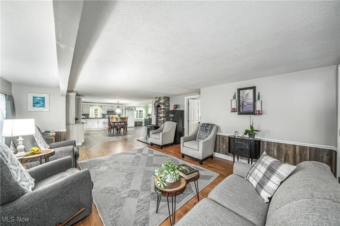 Living area featuring wood finished floors, a textured ceiling, and plenty of natural light