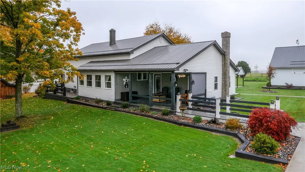 Back of property with a metal roof and a chimney