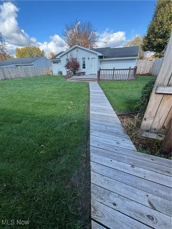 Rear view of property with a fenced backyard