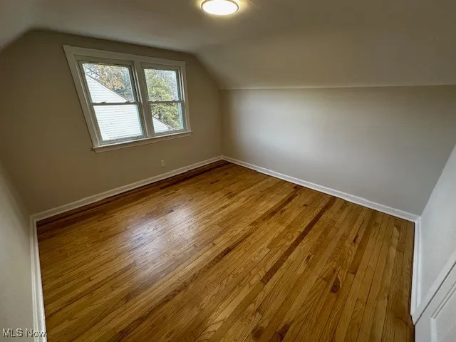 Bonus room with lofted ceiling and wood finished floors