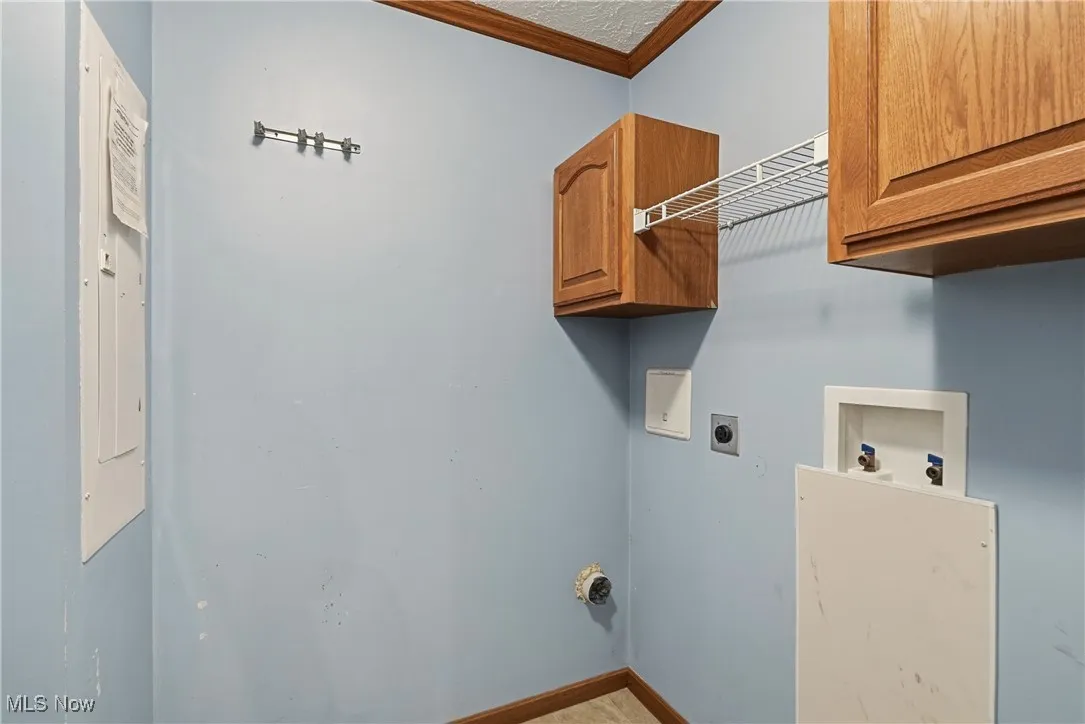 Laundry area hookup for a washing & dryer, cabinet space, electric dryer hookup, and electric panel