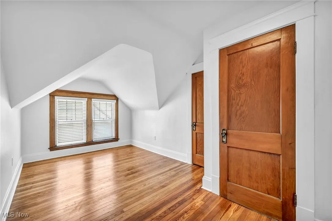 Bonus room featuring light wood-style flooring and lofted ceiling