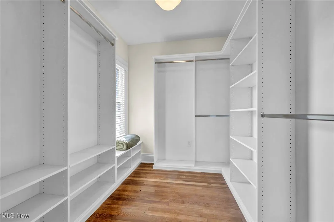 Walk in closet with light wood-style floors