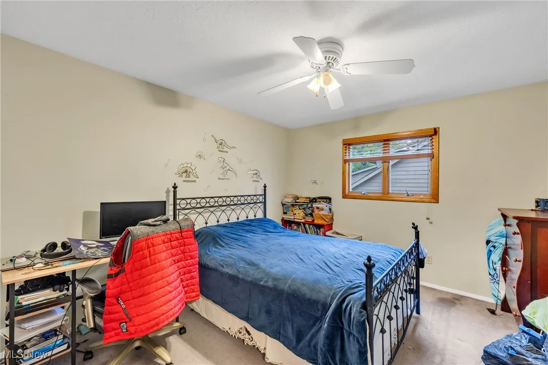 Carpeted bedroom with a ceiling fan