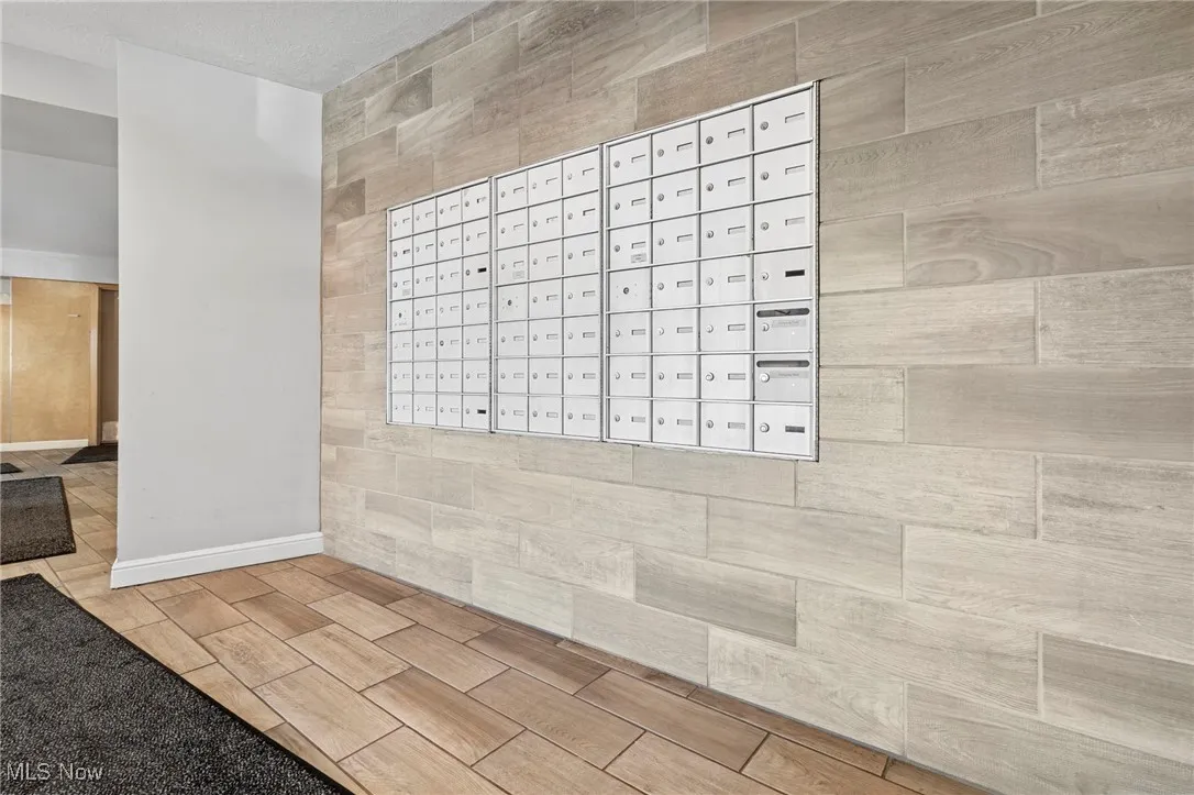 View of home's community with mail area and tile walls