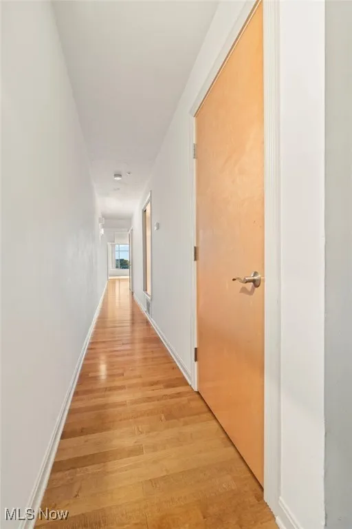 Corridor with light wood finished floors and baseboards