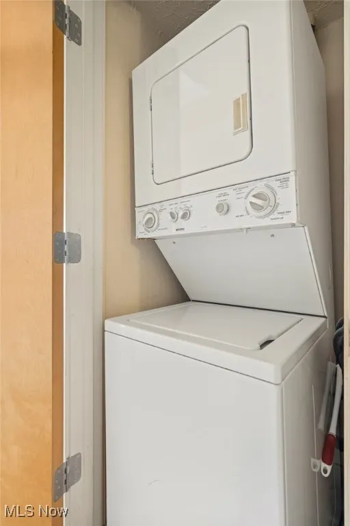Washroom featuring stacked washer / dryer
