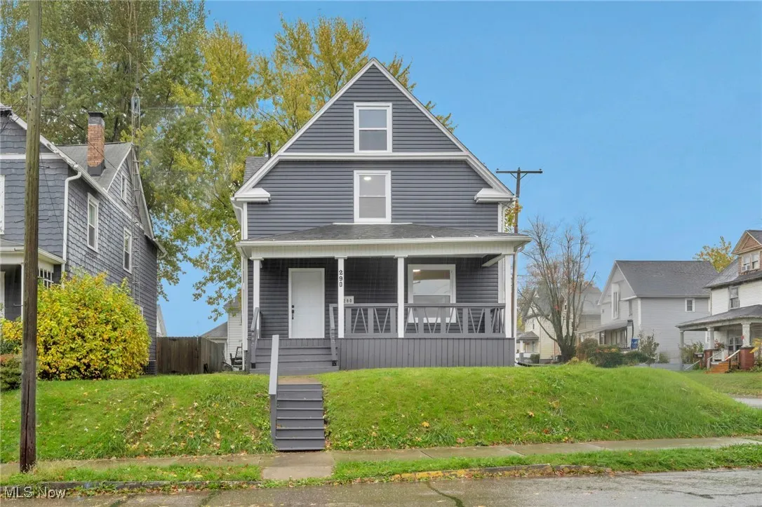 American foursquare style home featuring a porch and a front lawn